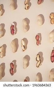 Peanut pattern on a light pastel beige background with peeled and unpeeled beans. Flat lay creative arrangement.	