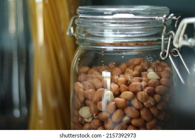 Peanuts, Haricot, Groundnut. Nuts In Glass Jar With Lid In Kitchen Counter. Raw Materials For Cooking. Food Ingredient Image For Interior Design, Background, Book, Website, Cover Page. Good Health