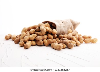 Peanuts in nutshell on white background and peeled peanuts.