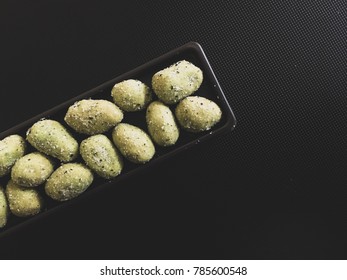 Peanuts Are Sprinkled With Wasabi Powder In A Tilt Tray On The Notebook