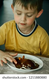 Pear Halves Coated With Chocolate Glaze And Decorated Like A Mouse. Creative Food, Funny Dessert For Picky Eaters. Little Boy Sitting At The Table And Tasting The Chocolate Mouse.