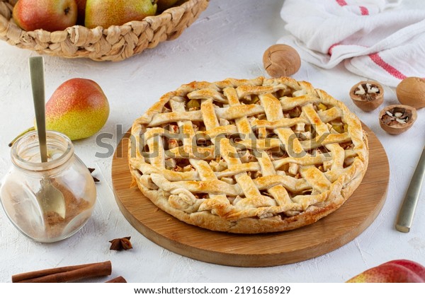 Pear pie with pastry lattice on the table\
with ingredients