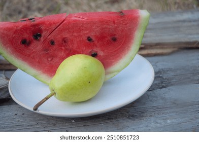 Pear and slice of watermelon on a plate on wooden background. No people. - Powered by Shutterstock