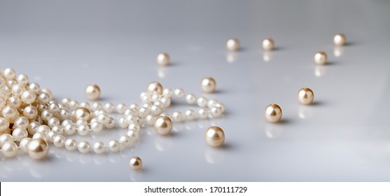 pearl beads and pearls with reflection on gray background