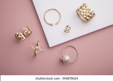 Pearl Golden Bracelets and ring on pink background - Pearl Bracelets on paper background setup  - Shutterstock ID 596878424