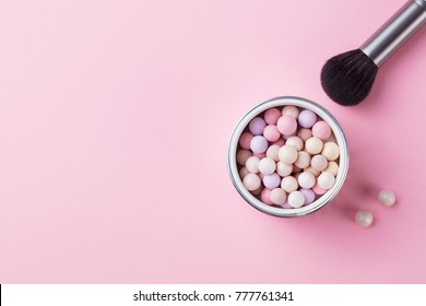 Pearl make up powder with brush on pink pastel background. Top view. Copy space.