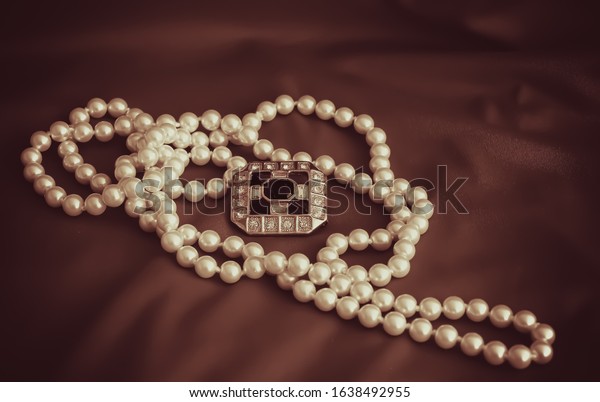 Pearl necklace on a\
vintage background.