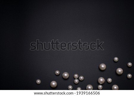 Pearls on the black background, with free space for text.