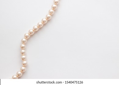Pearls on white background. Feminine necklace jewelry.
