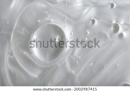 Pearly white thick creamy texture with bubbles. Soap or liquid cream with milky pearl colour.