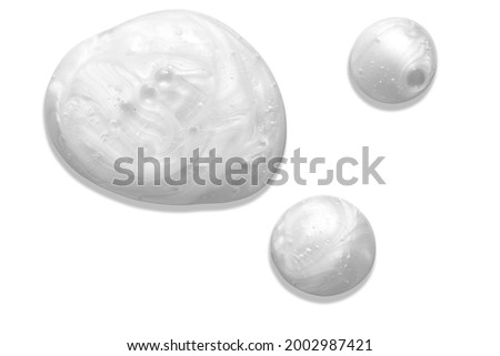 Pearly white thick creamy texture with bubbles. Soap or liquid cream with pearl colour on white background. Milky blobs.
