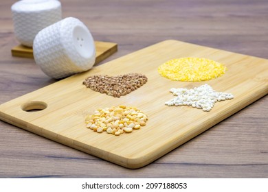 Peas, pearl barley, buckwheat, corn grits on a brown wooden table. Gluten free porridge. Heart shape, circle and asterisk - Powered by Shutterstock