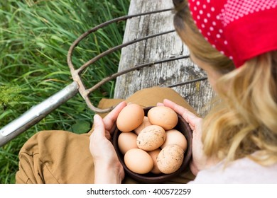 A peasant woman sitting on a bench with a bowl of eggs 