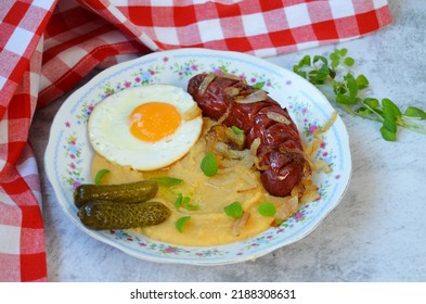 Pudding mit Würstchen, frittiertem Ei, Zwiebeln und Beizen - ein traditionelles tschechisches Gericht auf dem Teller