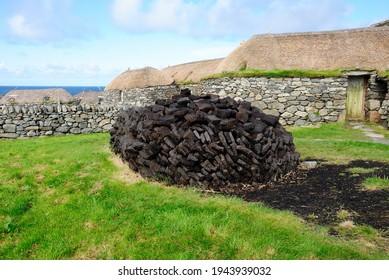 A Peat Stack And The Traditional Blackhouses On The Isle Of Lewis, Scotland, UK