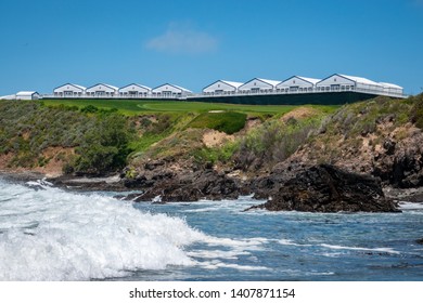 The Pebble Beach Golf Course, As Viewed From The Rocky Beach Below, As Tent Structures Are Erected For The Upcoming US Open Golf Tournament. 