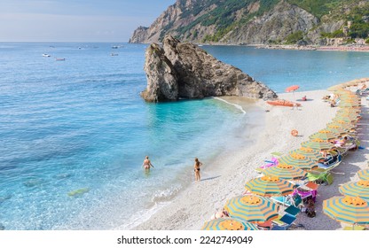 Pebble beach Monterosso vacation Cinque Terre Monterosso al Mare Chairs and umbrellas fill the Spiaggia di Fegina beach, Monterosso, part of the Cinque Terre Italy.  - Powered by Shutterstock