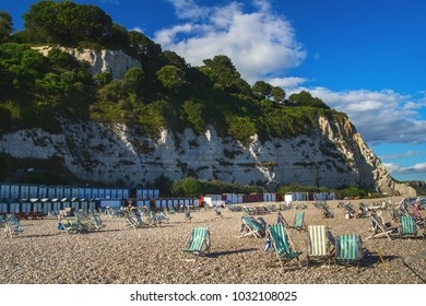 Pebble Beach Next To The Village Of Beer. Lots Of Sun Loungers. Small Boxes Under The Mountain. White Rock. Devon. UK