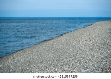 Pebble stone beach. Black Sea beach shore with waves in ocean. Waves in sea near coastline on empty pebble beach. Sea beach landscape. Coast pebbles. Shore landscape on Batumi resort. Ocean shoreline. - Powered by Shutterstock