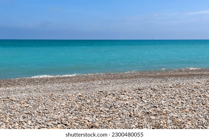 Pebble stone beach. Sea beach shore with waves in ocean. Waves in sea near coastline on empty pebble beach. Sea beach landscape. Coast pebbles. Shore landscape on Spain resort. Ocean shoreline scenic. - Powered by Shutterstock