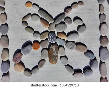 Pebble stone picture child craft made for school homework. Creative butterfly craft made from pebble stone on white wooden table background by child. Colorful pebble stones children hand craft concept - Powered by Shutterstock