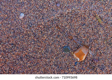 Pebbles On A Sandy Beach In Minnesota. On The Lake In Front Of The Cabin. Multi Colored Rocks.