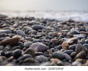 Pebbles on the seashore close-up. Rocky beach. Stones close-up with bokeh. Gray natural background. Autumn on the seashore. Waves and wet pebbles
 - Powered by Shutterstock