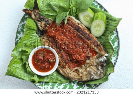 Pecak Bandeng or grilled milk fish with sour and spicy chili sambal. Perfect for recipe, article, catalogue or any cooking contents. 