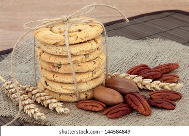 Pecan Chocolate Chip Cookie Stack With Nut Assortment And Wheat Over Hessian.