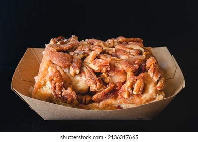 Pecan Frosted Cinnamon Roll Close Up On Black Background