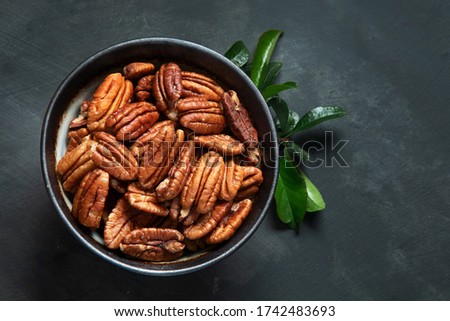 Pecan nuts in bowl. Top view with copy space