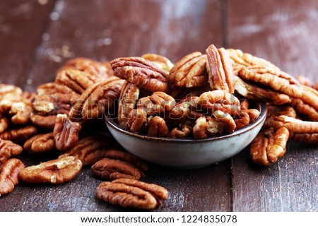 Pecan nuts on a rustic wooden table and pecan nuts in bowl. 商業照片 © 