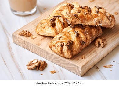 Pecan and walnut plait pastry filled with maple sirup on wooden board