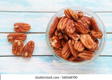 Pecans (Carya illinoinensis) on a blue table. Walnuts, hickory nuts