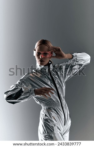 peculiar woman with sci fi glasses in futuristic attire doing robotic motions and looking at camera