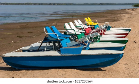 Pedalo rowing catamara stand on an empty sandy beach - pandemic, no people
