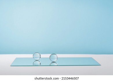 Pedestal cosmetic display glass podium platform with stylish props for product presentation, cosmetics geometric stand, mockup scene for jewellery. Balls and mirror on blue background - Shutterstock ID 2153446507