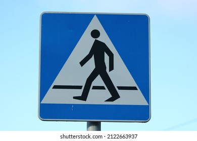 Pedestrain crossing sign against blue sky