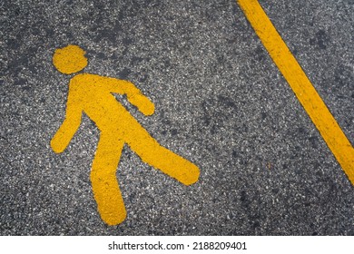 A pedestrain walking lane with human icon on asphalt road surface. Transportation symbol for safety background concept.