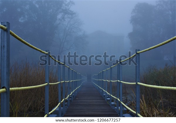 Pedestrian\
bridge near Mežotne\'s Palace in foggy\
morning