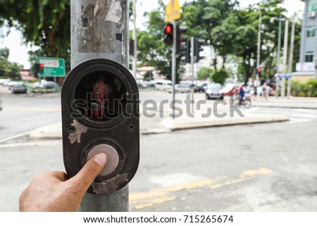 Pedestrian crossing call, push button with fingers close up
