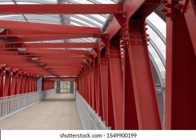 Fußgängerübergang, Bau von roten Metallkonstruktionen. Das Dach besteht aus Stahlkanälen, die miteinander verbunden sind. Rote Eisenstangen auf Bolzen und Nieten.