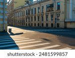 Pedestrian crossing on an empty street flooded with sunlight in an old European city