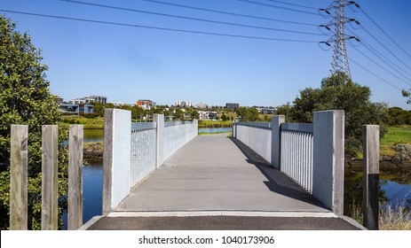 Pedestrian Footbridge Over River With Modern Residential Houses In Distance. City Of Maribyrnong, VIC Australia.
