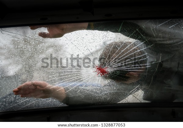 Pedestrian hit by a car, with blood on the
splintered
windshield