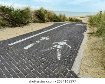 Pedestrian pathway leading to a serene beach with sea grass along the sides. Clear sky and sandy dunes create a tranquil atmosphere, perfect for travel, nature, and outdoor lifestyle themes. - Powered by Shutterstock