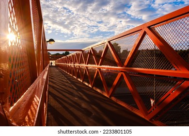 For pedestrian safety, a fenced-in metal walkway crosses over a road. - Shutterstock ID 2233801105