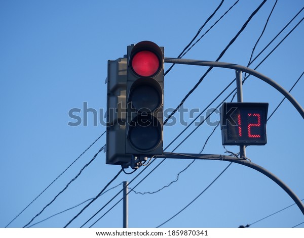 Pedestrian traffic light with a countdown timer on\
the background of\
wires.