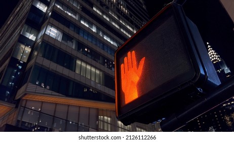 Pedestrian traffic light hangs at an intersection in New York, USA. Red stop signal. Traffic management on the road. Transport in the city. Stoplight. Night midtown Manhattan. - Shutterstock ID 2126112266