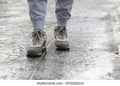 A pedestrian walks along a dangerous icy sidewalk. Frozen rain.